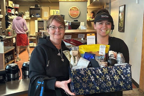Brenda Bannister (left) with a Timber Hitch staff member, showing off the raffle basket. Photo courtesy of Timber Hitch Coffee Shop & Drive Thru.